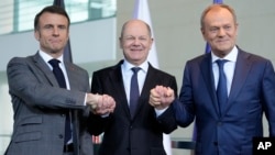 El canciller alemán Olaf Scholz (centro), el presidente francés Emmanuel Macron (izquierda) y el primer ministro polaco Donald Tusk se dan la mano en una conferencia de prensa en Berlín, Alemania, el viernes 15 de marzo de 2024.