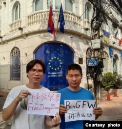 拆墙运动倡导者乔鑫鑫、烽烨在欧盟驻万象使团周边举牌。（乔鑫鑫提供图片）