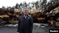 Кір Стармер, лідер Лейбористської партії Великої Британії, біля цивільних автомашин знищених внаслідок російського наступу в місті Ірпінь під Києвом під час його візиту в Україну 16 лютого 2023 р.