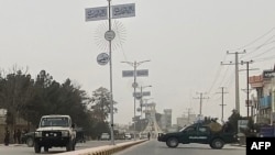 Personel keamanan Taliban (kanan) memblokir jalan di Mazar-i-Sharif , menyusul ledakan di kantor gubernur Taliban Mohammad Dawood Muzammil, di provinsi Balkh Afghanistan, 9 Maret 2023. (Atif ARYAN/AFP)