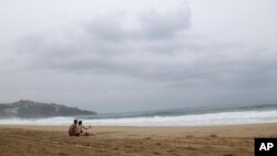 ARCHIVO - Turistas sentados en la playa de Acapulco, México, el martes 24 de octubre de 2023.