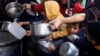 Arhiv - Palestinska djeca čekaju da prime obrok koji su pripremile humanitarne kuhinje usred nestašice hrane u Rafahu, na ugu Pojasa Gaze, 5. marta 2024.