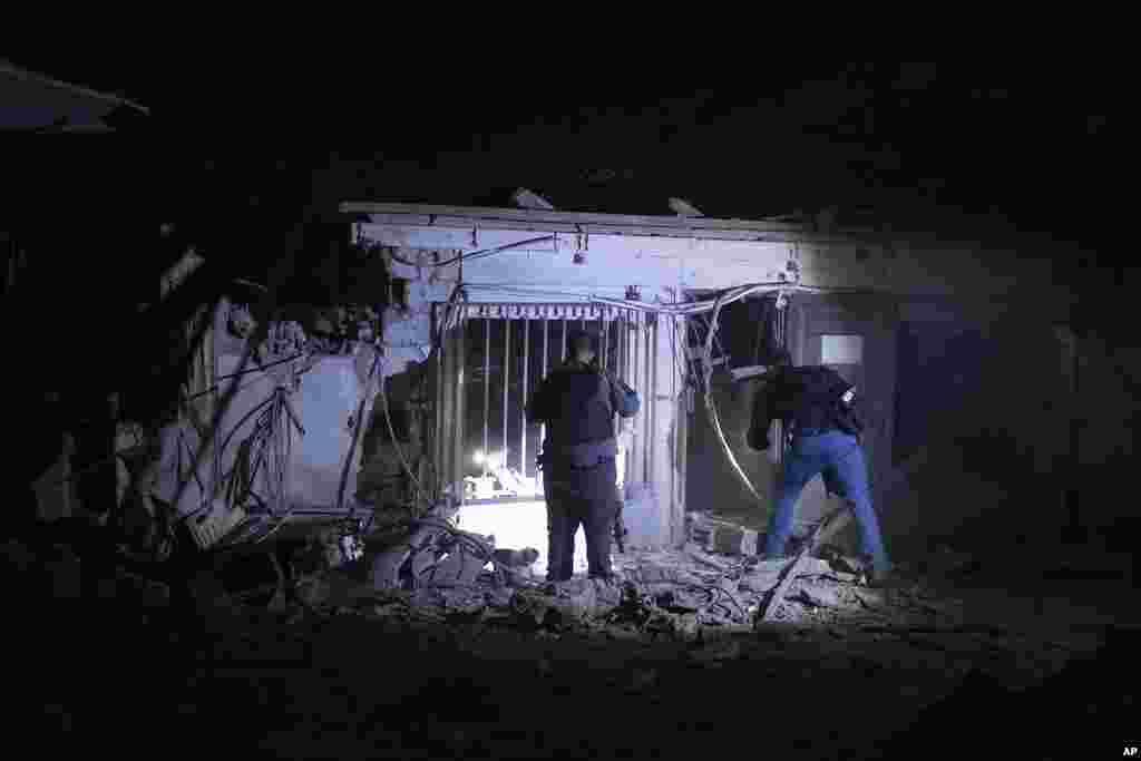 Israeli police check the damage from a rocket fired from the Gaza Strip in Tel Aviv, Israel, Oct. 7, 2023.
