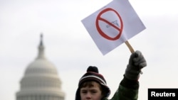 Peyton Tremont, de siete años, porta una pancarta durante una manifestación para regular las armas en Washington, el 26 de enero de 2013.