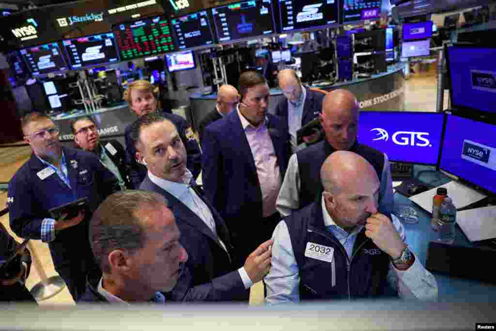 Traders and floor officials react to technical issues on the floor at the New York Stock Exchange (NYSE) in New York City. The glitch triggered massive swings in the shares of Berkshire Hathaway BRKa.N and Barrick Gold GOLD.N, and trading halts in dozens of other companies, before the bourse fixed the problem.