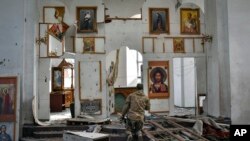 Український військовослужбовець молиться на колінах у церкві, яка постраждала від російської авіації в місті Оріхів, Запорізька область, Україна, п'ятниця, 5 квітня 2024 року. (AP Photo/Андрій Андрієнко)
