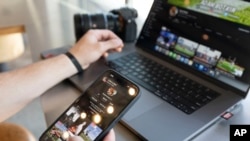 Adam Botkin, a seorang influencer sepak bola di TikTok, tampak mengedit videonya untuk diunggah ke akunnya ketika ia berada di restoran Chipotle Mexican Grill di Missoula, Montana, pada 3 Mei 2023. (Foto: AP/Tommy Martino)