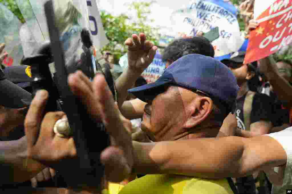 Activists try to hold their ground as police tried to block them from holding a protest near the Chinese consulate in Makati, Philippines. The group is protesting the continued aggression of China at the disputed South China Sea.
