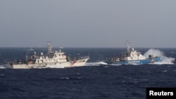 资料照：在离越南海岸大约210公里的南中国海上，从一艘越南海岸警卫队的船上看附近的中国海警船。（2014年5月14日）