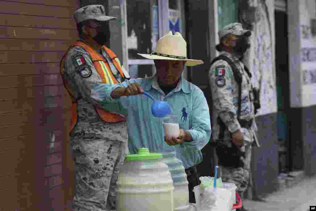 Un vendedor sirve bebidas mientras la ceniza del volcán Popocatépetl cubre las calles de Santiago Xalitzintla, México. Las autoridades le han estado diciendo a la gente que se mantenga fuera del radio de 12 kilómetros (7,5 millas) alrededor del pico.
