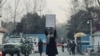 Seorang perempuan muda melakukan aksi protes seorang diri terhadap larangan bagi perempuan untuk menempuh bangku pendidikan tinggi yang diterapkan oleh Taliban, di luar Universitas Kabul di Afghanistan, pada 25 Desember 2022. (Foto: AFP)
