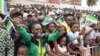 Des habitants agitent des drapeaux lors d'un défilé militaire à l'occasion de la fête de l'indépendance du Gabon, à Libreville, le 17 août 2024.