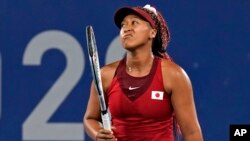 FILE - Naomi Osaka, of Japan, reacts after losing a point to Marketa Vondrousova, of the Czech Republic, during the third round of the tennis competition at the 2020 Summer Olympics, July 27, 2021, in Tokyo, Japan.