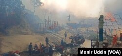 Rohingya refugees take shelter on a canal bank as fire guts through shanties in Balukhali refugee camp in Bangladesh, March 5, 2023.
