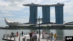 La gente toma fotografías en el embarcadero del paseo marítimo de Marina Bay en Singapur el 17 de noviembre de 2023.