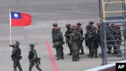 FILE - Seorang tentara mengibarkan bendera nasional Taiwan selama latihan militer tahunan Han Kuang di Taoyuan, Taiwan Utara, 26 Juli 2023. (Chiang Ying-ying/AP)