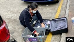 上水街頭疑似水貨客蹲在地上處理貨物，可能造成阻街問題。(美國之音湯惠芸)