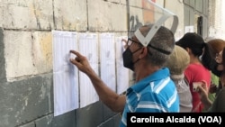 Un ciudadano ubica la mesa en la que le corresponde votar en las elecciones regionales y municipales celebradas en Venezuela en 2021.