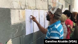 Un ciudadano ubica la mesa en la que le corresponde votar en las elecciones regionales y municipales celebradas en Venezuela en 2021.
