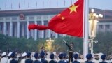 Китайский почетный караул разворачивает национальный флаг Китая на церемонии, посвященной 73-й годовщине основания Китайской Народной Республики, Пекин, 1 октября 2022 года.