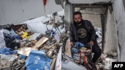 A man salvages food packages from a building that was hit overnight during Israeli bombardment in Rafah in the southern Gaza Strip, March 26, 2024.