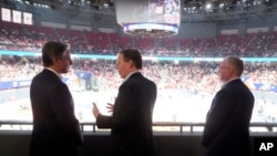 El secretario de Estado de EEUU, Antony Blinken, conversa con el embajador de EEUU en China, Nicholas Burns (centro) y el cónsul general en Shanghai Scott Walker en un partido de baloncesto entre los Shanghai Sharks y los Zhejiang G. B. en Shanghai, el 24 de abril de 2024.