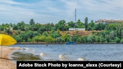FILE - Strilka beach on the Inhul River in Mykolaiv, Ukraine. City beach near shallow water and the inscription Mykolaiv on the shore on July 26, 2020 (Adobe stock photo)