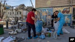 Workers try to salvage intact medical equipment in the hospital yard at the site of Okhmatdyt children's hospital hit by a Russian missile the day before, in Kyiv, Ukraine, July 9, 2024.