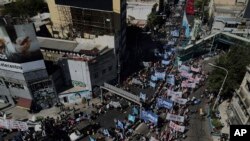 ARCHIVO - Argentinos marchan contra la pobreza y exigen más programas sociales del gobierno mientras bloquean el Puente Pueyrredon, el principal punto de entrada a Buenos Aires, el miércoles 5 de abril de 2023. 