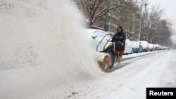 一名工人在北京街头扫雪。（2023年12月14日）