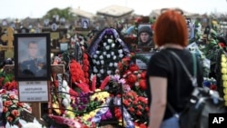 Росіянка біля м.Волгоград, Росія, відвідує цвинтар, де поховані російські солдати, які загинули на війні Росії проти України, травень 2022 року. Фото: АР