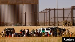Migrantes son detenidos por agentes de la Patrulla Fronteriza de EEUU después de cruzar el río Bravo para entregarse y solicitar asilo en El Paso, Texas, EEUU, visto desde Ciudad Juárez, México, el 29 de marzo de 2023.