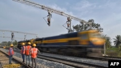 印度鐵路公司的合同工在班加羅爾郊區架設用於在鐵軌上牽引電纜線供機車使用的設施。（資料照片，2021年1月15 日）