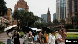 2023 年 4 月 30 日，在中国澳门五一劳动节假期期间，游客在金沙中国运营的伦敦澳门赌场度假村的大本钟复制品前拍照。