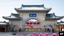 資料照片：2020年1月23日，遊客走過中國吉林省吉林市北山公園的大門。 (美聯社照片)