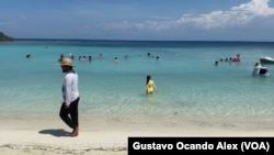 Vladimir Ríos, un prestador de servicios de trampolines y botes inflables, camina por la playa del cayo Playuela en el estado Falcón, Venezuela.