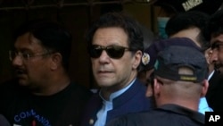 Pakistan's former Prime Minister Imran Khan is escorted by security officials as he arrives at court in Islamabad, Pakistan, May 12, 2023.