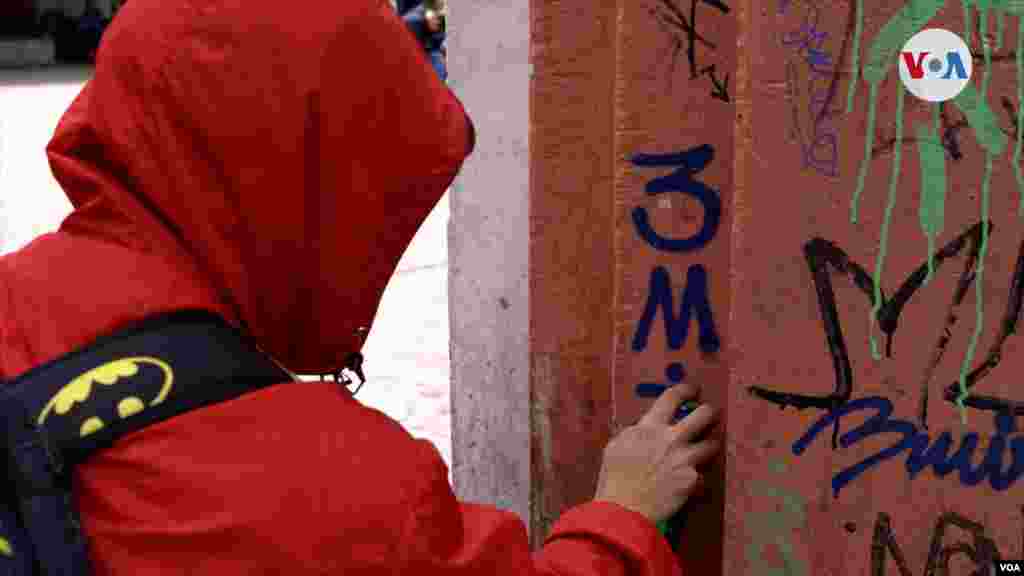 3Miro realizando un graffiti de escritura en una de las calles de La Candelaria. FOTO: Johan Reyes, VOA.