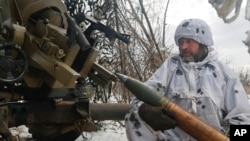Seorang tentara Ukraina bersiap menembakkan artileri ke arah posisi pasukan Rusia di dekat Bakhmut, Wilayah Donetsk, Ukraina, 15 Februari 2023. (Foto: Roman Chop/AP Photo)