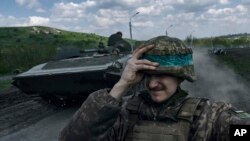2023年4月26日，一名乌克兰士兵在乌克兰顿涅茨克地区巴赫穆特乘坐装甲运兵车时手拿头盔。（美联社照片）