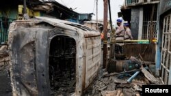 Oficiales de policía vigilan una zona residencial afectada después de que estallara un incendio anoche en una estación de almacenamiento de combustible operada por la compañía energética estatal de Indonesia, Pertamina, en Yakarta, Indonesia, el 4 de marzo de 2023. 