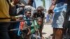 Youth take cover after hearing gunshots at a public school that serves as a shelter for people displaced by gang violence in Port-au-Prince, Haiti, March 22, 2024.
