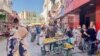 Tunisians wait in line for bread. Subsidized staples like flour and milk are sometimes hard to find. (Lisa Bryant/VOA)