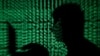 Un hombre sostiene una computadora portátil mientras se le proyecta un código cibernético en esta fotografía ilustrativa tomada el 13 de mayo de 2017.