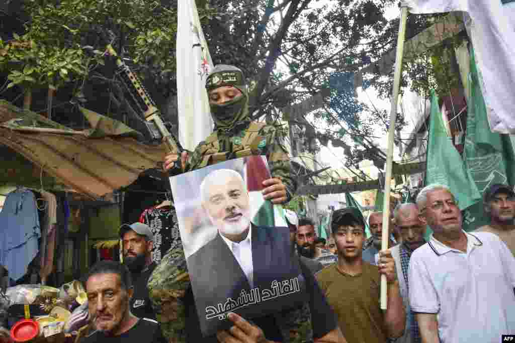 Demonstrators wave flags and hold pictures of the leader of the Palestinian militant Hamas group, Ismail Haniyeh, during a protest in Beirut's Burj al-Barajneh camp for Palestinian refugees, Lebanon, denouncing his killing. Hamas said its political leader was killed in an Israeli strike in Iran, where he was attending the swearing-in of the new president.
