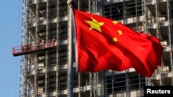 中国国旗在北京一处正在施工的楼盘前飘扬。（2013年11月4日）