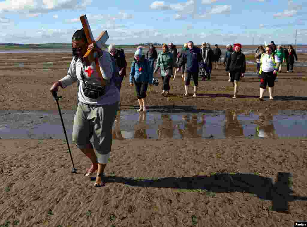 Peregrinos de la Cruz del Norte realizan la peregrinación cristiana anual con la cruz a Lindisfarne (Isla Santa) que tiene lugar el Viernes Santo en Northumberland, Gran Bretaña.