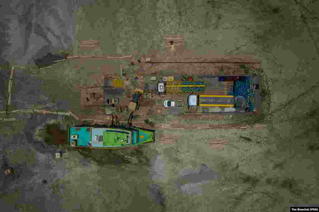 A barge loaded with gas cylinders, a fuel transport truck, and its tugboat became stuck in the mud after the waters of the Rio Negro receded dozens of meters in recent weeks in Manau, Oct. 3, 2023.
