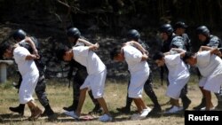Presuntos miembros de la pandilla Barrio 18 son presentados ante los medios de comunicación luego de ser arrestados por la desaparición o asesinato de varias personas, incluidos dos conductores de entrega de comida rápida, en Colón, El Salvador, el 3 de marzo de 2022.