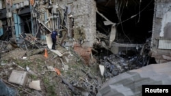 Un fiscal de crímenes de guerra trabaja en el lugar de un ataque aéreo ruso en Kharkiv, Ucrania, el 25 de mayo de 2024.